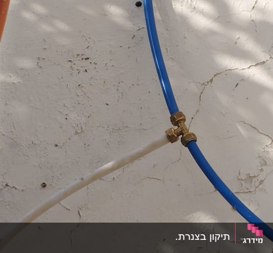 צינורות צבעוניים מחוברים עם מחבר מתכת על קיר